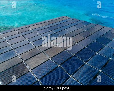 Vista aerea della centrale solare galleggiante di SolarSea presso Swimsol con file di pannelli fotovoltaici sulle acque turchesi dell'oceano a Dharavandhoo, Atollo di Baa, ma Foto Stock