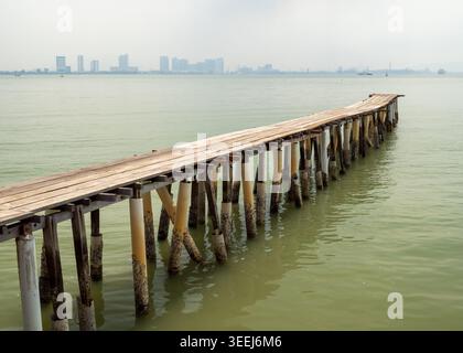 Ampia vista prospettica di un lungo molo tradizionale in legno che si estende in un mare calmo, George Town, Penang, Malesia Foto Stock