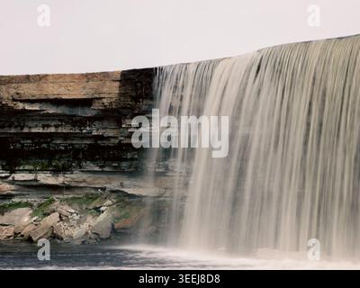 Cascata di Jägala che si estende su un argine calcareo nella piscina del fiume in primavera, contea di Harju, Estonia Foto Stock