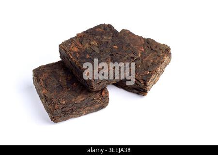 Tè cinese pu-erh nero. Piastrelle pressate di tè nero fermentato isolate su sfondo bianco. Foto Stock