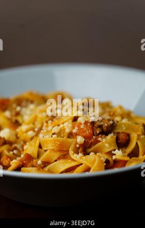 Tagliatelle con ragù alla bolognese servite in una ciotola di ceramica azzurra. Foto Stock