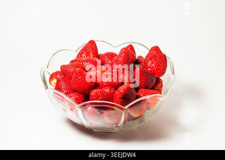 Shot di una ciotola di vetro piena di fragole isolate su bianco. Foto Stock
