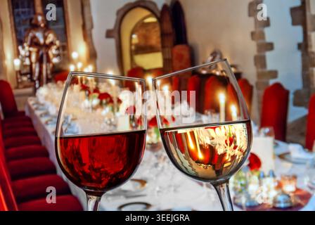 Bicchieri da vino tavolo a lume di candela bicchieri da vino rosso e bianco che strizzano "saluti" in primo piano di un banchetto formale di lusso a lume di candela cena di festa al tavolo Foto Stock