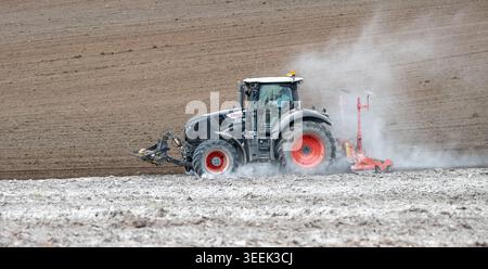Claas Axion 830 eruttante di potenza in calce appena sparsa su un campo arato. Il calcare in polvere aiuta la fertilità del terreno. Cumbria, Regno Unito. Foto Stock