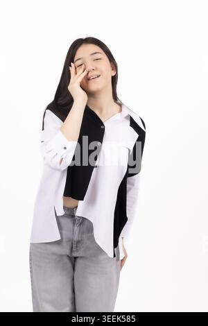 Giovane donna che ride e posa su sfondo bianco per professionisti Foto Stock