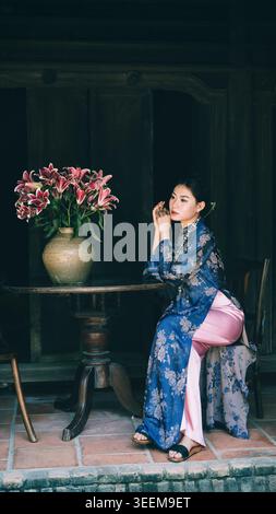 bella donna vietnamita che indossa ao dai in interni vintage. Nha Trang, Vietnam - 25 gennaio 2026. Foto Stock