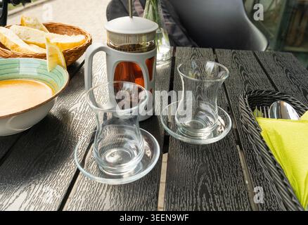 Tè turco su un tavolo da caffè, tradizionale tazza araba nel ristorante, tè nero bevuto in tazza turca, colazione araba Foto Stock