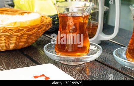 Tè turco su un tavolo da caffè, tradizionale tazza araba nel ristorante, tè nero bevuto in tazza turca, colazione araba Foto Stock