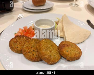 Falafel nel ristorante, pezzi rotondi di ceci fritti, falafel tradizionali, piatti halal arabi speziati, falafel su sfondo sfocato Foto Stock