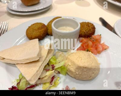 Falafel nel ristorante, pezzi rotondi di ceci fritti, falafel tradizionali, piatti halal arabi speziati, falafel su sfondo sfocato Foto Stock