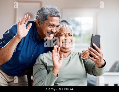 Wave, coppia felice e senior con telefono per videochiamate, comunicazioni e chat online a casa. Pensione, saluto e ciao di vecchio e.. Foto Stock