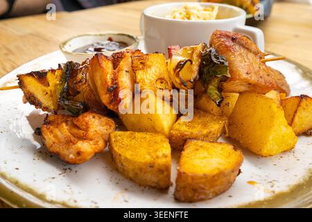 Pollo Shish Kebab, barbeque Shashlik, spiedini alla griglia con carne e verdura, frutta, peperoni, cipolle e ananas, servito con Coleslaw e. Foto Stock