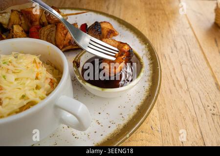 Pollo Shish Kebab, barbeque Shashlik, spiedini alla griglia con carne e verdura, frutta, peperoni, cipolle e ananas, servito con Coleslaw e. Foto Stock