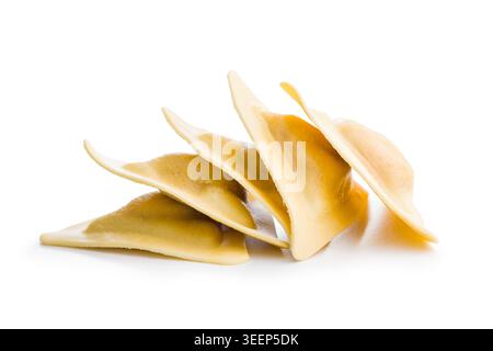 Gnocchi di pasta italiana cruda impilati su sfondo bianco. Le conchiglie in stile ravioli freschi e fatti in casa mettono in risalto la consistenza liscia dell'impasto e la rustica Foto Stock