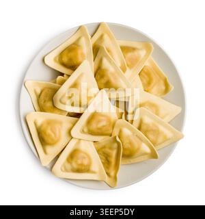 Ravioli triangolari disposti su un piatto bianco, con impasto fresco crudo e tasche ripiene. Ideale per ricette italiane, cucina, cibo confezionato Foto Stock