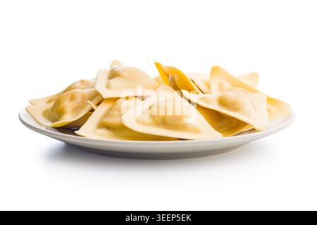 Ravioli triangolari disposti su un piatto bianco, con impasto fresco crudo e tasche ripiene. Ideale per ricette italiane, cucina, cibo confezionato Foto Stock