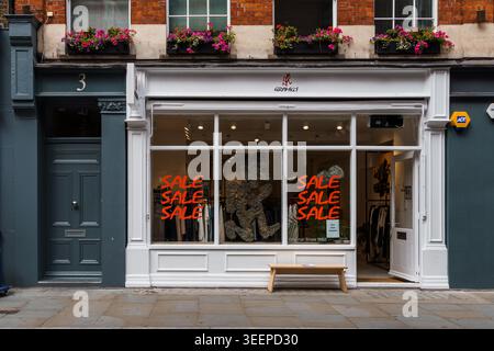 Londra, Regno Unito - 27 agosto 2023: Un negozio a Covent Garden, Londra, con i cartelli "SALE" nella finestra e le fioriere sopra. Foto Stock