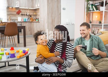 Una famiglia allegra trascorre del tempo di qualità a giocare nella propria casa invitante. Foto Stock