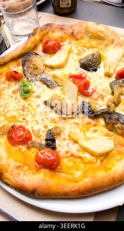 Foto ravvicinata di una deliziosa pizza vegetariana condita con colorate verdure fresche Foto Stock