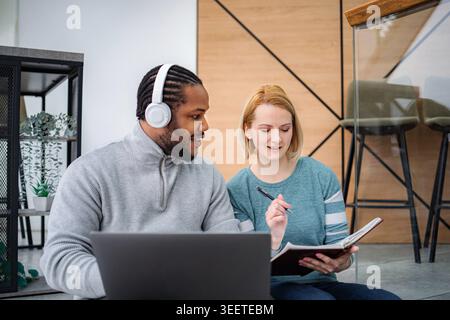 Studenti diversi che collaborano con un notebook studiando insieme Foto Stock