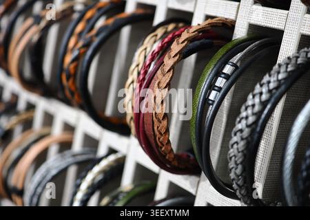 Bracciali in pelle esposti su un rack in legno in vendita Foto Stock