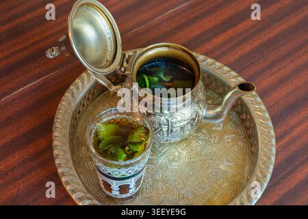 Tè marocchino alla menta in teiera e bicchiere, tradizionale bevanda araba dal Marocco Foto Stock