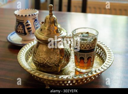 Tè marocchino alla menta in teiera e bicchiere, tradizionale bevanda araba dal Marocco Foto Stock