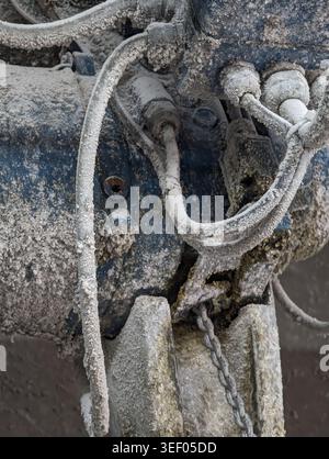 Primo piano di raccordi e flessibili idraulici corrosi che mostra connettori in metallo ossidato e sporcizia pesante, ambiente di officina con residui di olio, guarnizioni usurate, th Foto Stock