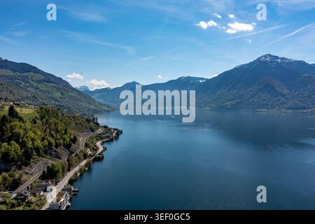 Panorama aereo del litorale del Lago di Zugo e delle vette alpine - tranquilla vista del lago svizzero con riflessi blu Foto Stock