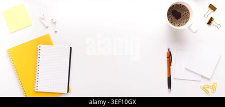 Caffè del mattino sul posto di lavoro con giallo cancelleria e blocco note Foto Stock