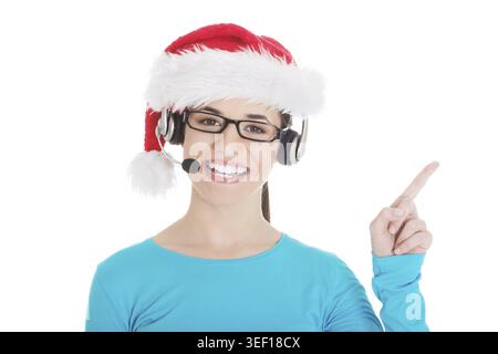Giovane donna casual con cappello babbo natale e microfono e cuffie. Isolato su bianco Foto Stock