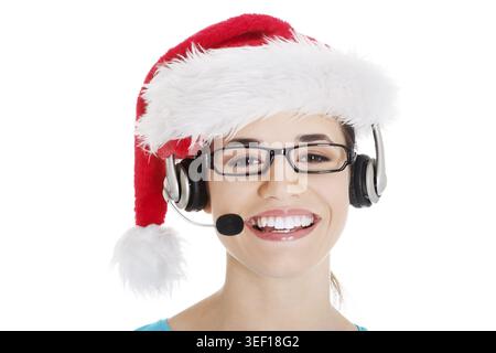 Giovane donna casual con cappello babbo natale e microfono e cuffie. Isolato su bianco Foto Stock