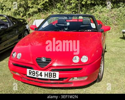 Rossa Alfa Romeo Spider 916 convertibile con registrazione UK R854 HBB parcheggiata sull'erba in un salone di auto d'epoca nel Regno Unito Foto Stock