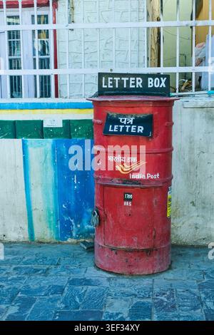 Cassetta postale della Red India Post sulla strada, simbolo del servizio postale tradizionale e infrastruttura di comunicazione quotidiana in Himalaya Foto Stock