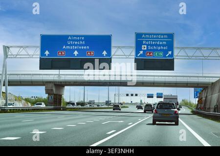 Paesi Bassi - 17 aprile 2026: Traffico diurno sull'autostrada A9 in prossimità di un importante interscambio con segnali stradali diretti ad Almere, Utrecht, AMS Foto Stock