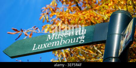 Segui le indicazioni per il museo del Palazzo del Lussemburgo e per gli alberi autunnali sullo sfondo. Giardini del Lussemburgo a Parigi (Francia). Foto Stock