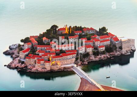 Sveti Stefan, città storica fortificata del Montenegro su un'isola al crepuscolo. Foto Stock