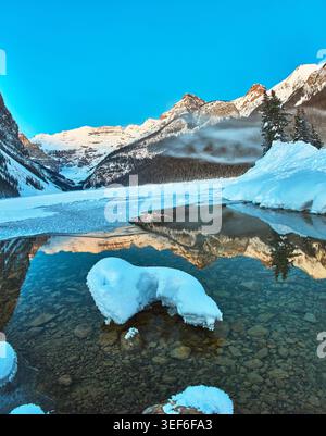 Vista panoramica invernale delle cime innevate del Lago Louise e del cielo azzurro Foto Stock