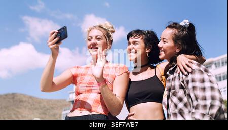 Amici, donne e videochiamate all'aperto per aggiornamenti sui viaggi, weekend e divertimento in estate. Salve, Wave e influencer o gruppo con comunicazione, vlog Foto Stock