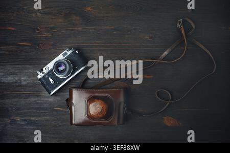 Vecchia fotocamera retrò su sfondo vintage in legno. Posizione piatta Foto Stock