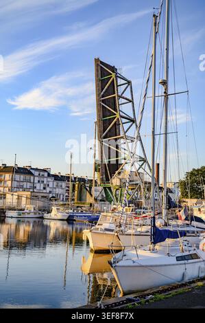 Nel bacino del porto, barche a vela bianche e yacht si trovano di fronte alla strada rialzata del caratteristico ponte pieghevole verde Pont Basculant, mentre la S Foto Stock