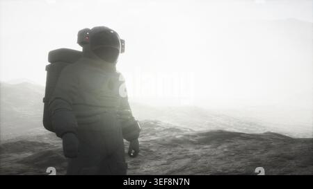 Astronauta su un altro pianeta con polvere e nebbia Foto Stock