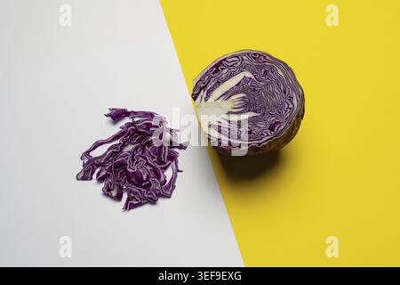 Un cavolo rosso tagliato a metà e posto su una superficie colorata Foto Stock