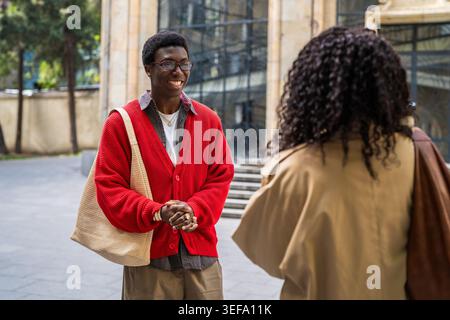 Uomini e donne afroamericani positivi studenti di coppia che dicono addio dopo l'incontro in strada. Foto Stock