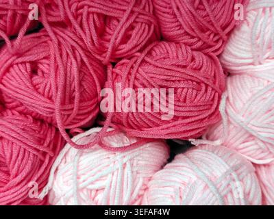 Primo piano di palle in filato multicolore impilate insieme, fibra morbida, materiale per maglieria, sfondo a cornice intera Foto Stock