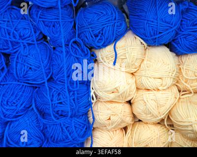 Primo piano di palle in filato multicolore impilate insieme, fibra morbida, materiale per maglieria, sfondo a cornice intera Foto Stock