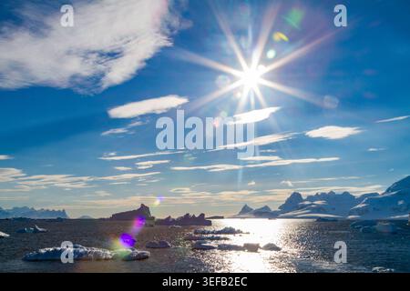 Iceberg e montagne nella Paradise Bay sotto la luce del sole in Antartide Foto Stock
