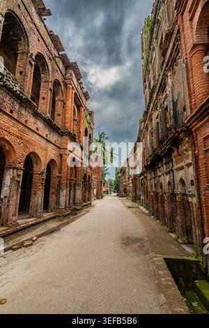 Edifici storici in mattoni fiancheggiano una strada tranquilla sotto un cielo nuvoloso in una zona della città vecchia durante il giorno Foto Stock