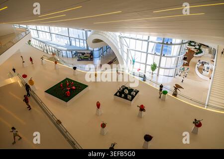 I visitatori si confrontano con l'arte e l'architettura del centro Heydar Aliyev, che mostra un design moderno a Baku, Azerbaigian Foto Stock