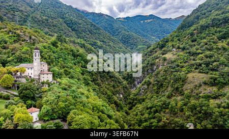 Vista della chiesa della resurrezione circondata da verdi colline e montagne vicino al Lago di Como in Italia Foto Stock